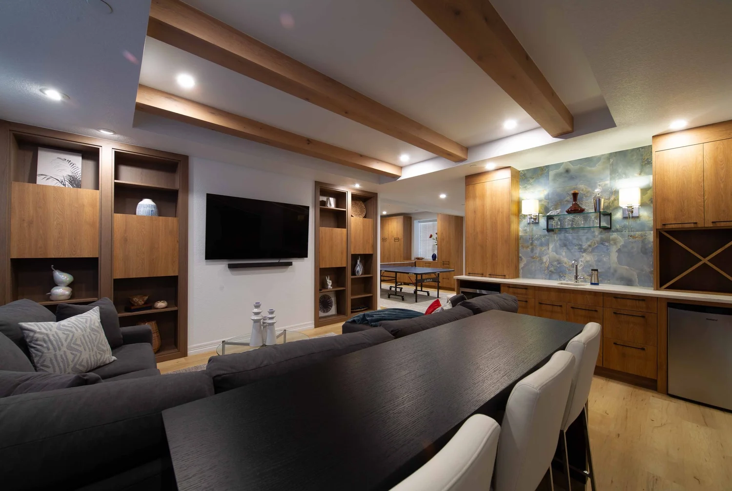 CD8G0026 Highlands Country Club finished basement with modern lighting, custom cabinetry, wood beam detailing and wet bar. Completed with marble countertops and colorful blue backsplash.