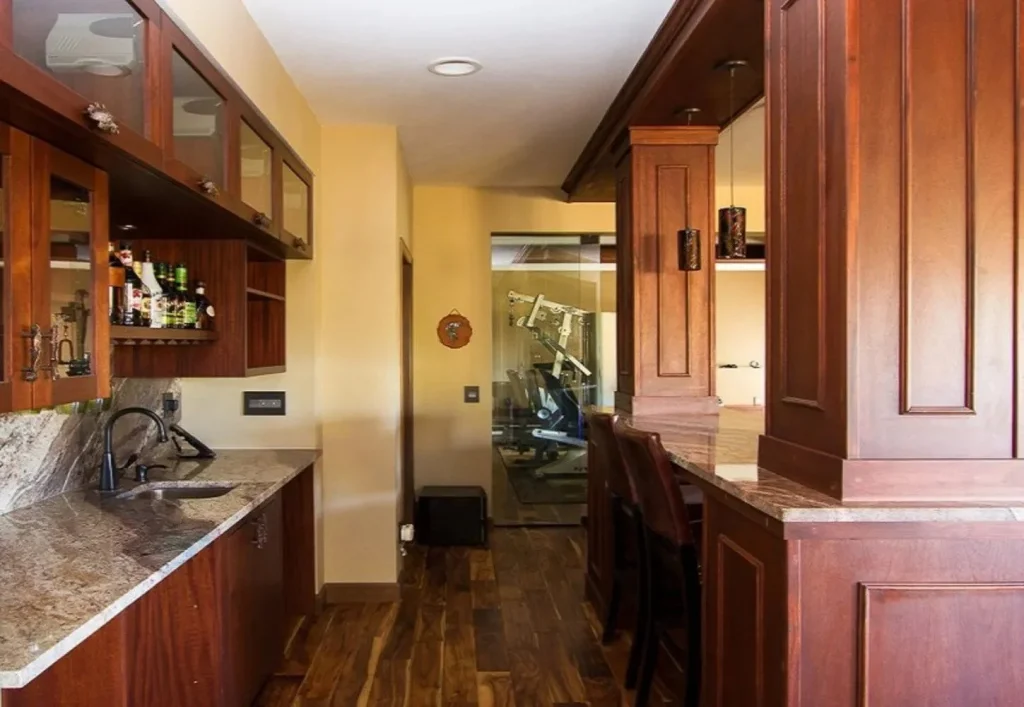 CD8G0063 Colorado basement redesign with mahogany custom cabinetry, granite countertops, and wet bar.