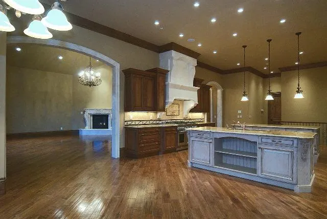 CPV3-1-1944da5e-1920w Denver custom home remodel. Full kitchen remodel complete with granite countertops, custom cabinetry, modern lighting hardwood floors, customized fireplace and wood detailing. Kitchen island with storage.